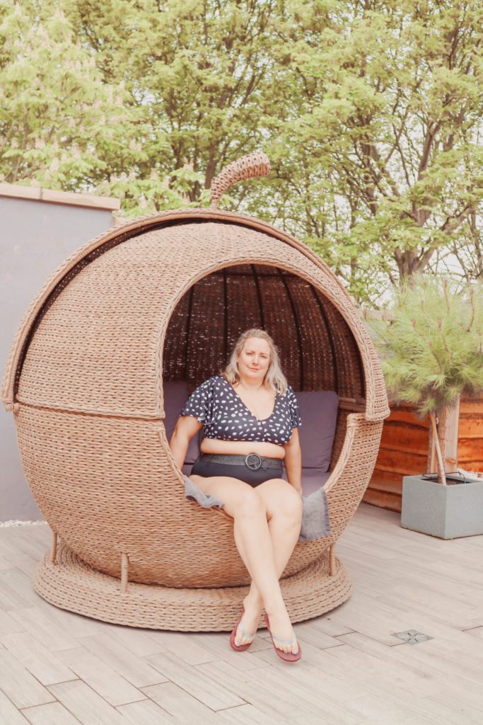 lucy sat in a rattan apple shaped day bed at the inside of the pool at ye olde bell spa