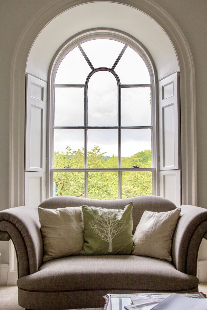 arched window with chair in front inside a cottage 