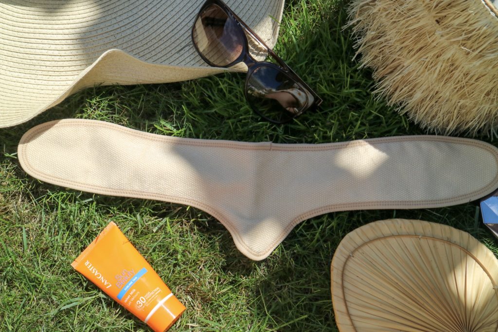 chafree sweat liner in nude on grass with summer essentials around it 
