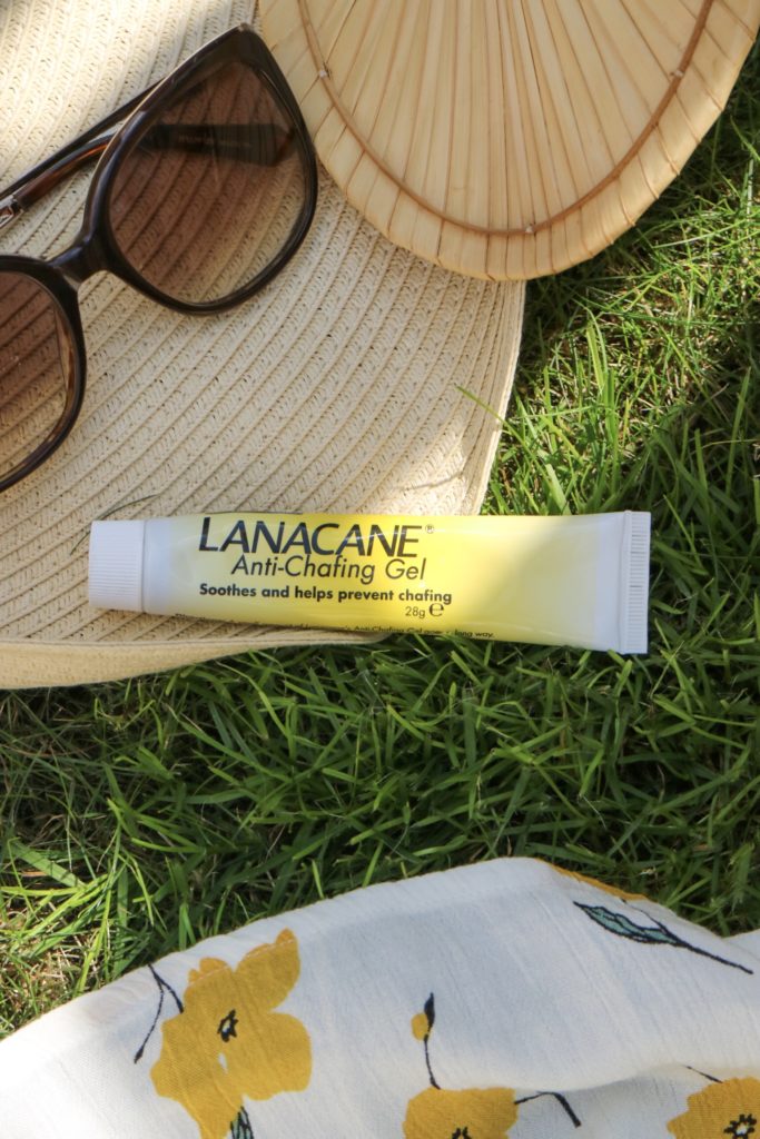 lanacane anti chafing gel on grass with a straw hat and sunglasses 