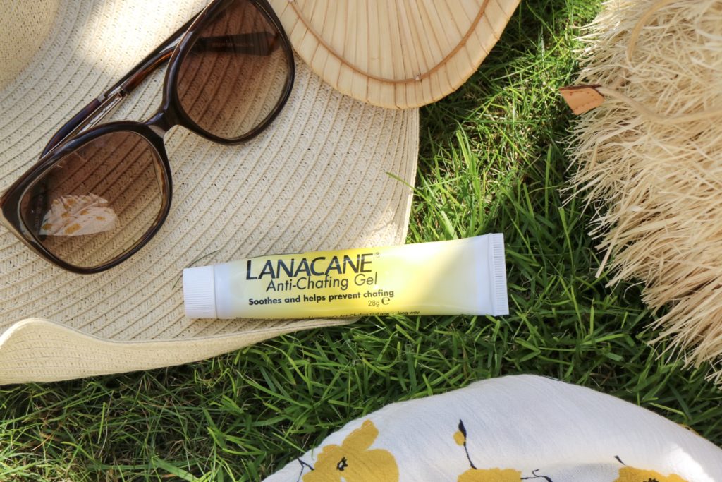 lanacane anti chafing gel on grass with a straw hat and sunglasses 