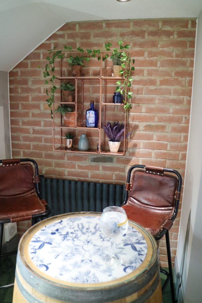 two high stools and table with a brick wall and shelves