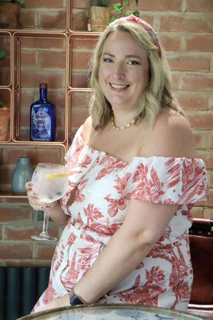 me in a red and white bardot dress with a G&T in hand