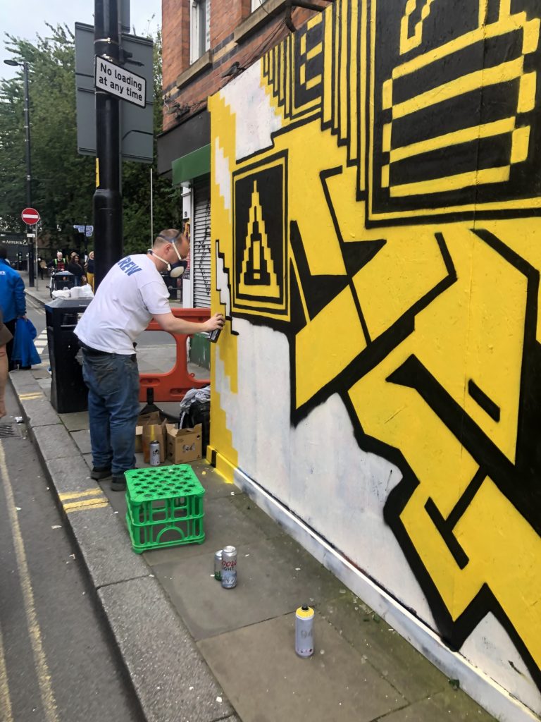 man painting street art in manchester