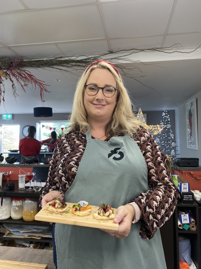 lucy proudly showing off three blinis on a board