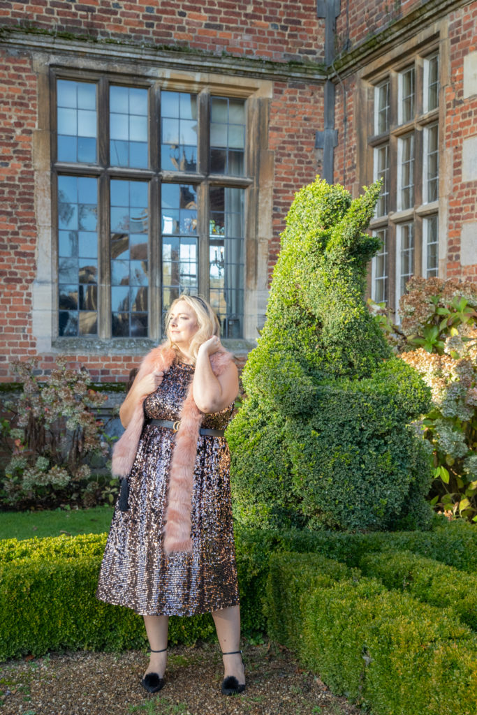 lucy infront of a topiary unicorn