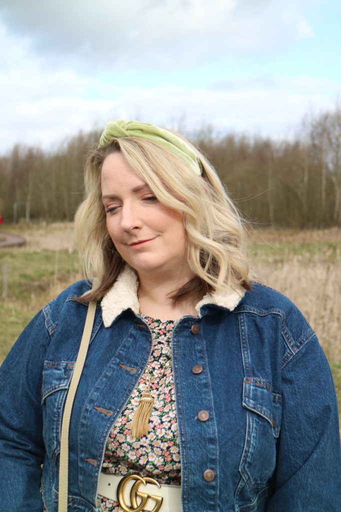 lucy in a field in a floral dress and headband